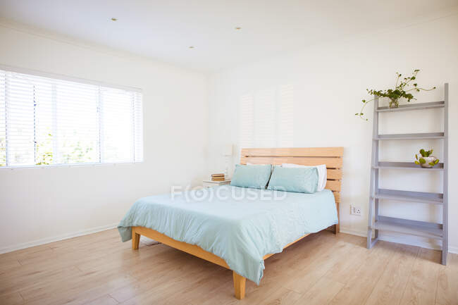 A view of empty bedroom with bed, shelf and window. home styling and interior design concept. — Stock Photo