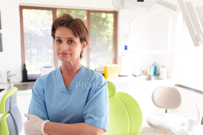 Портрет усміхненої жінки-стоматолога, яка дивиться на камеру в сучасній стоматологічній клініці. Медичне обслуговування та стоматологія. — стокове фото