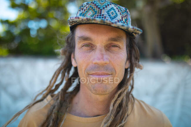 Close-up portrait of male hipster mural painter with long dreadlocks hairstyle wearing cap. hipster people. — Stock Photo