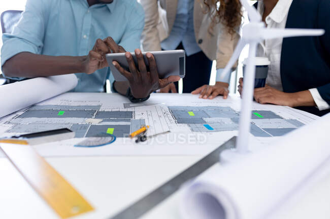 Midsection de arquitetos masculinos e femininos discutindo sobre tablet digital na mesa no escritório. negócio, arquiteto e escritório criativo. — Fotografia de Stock