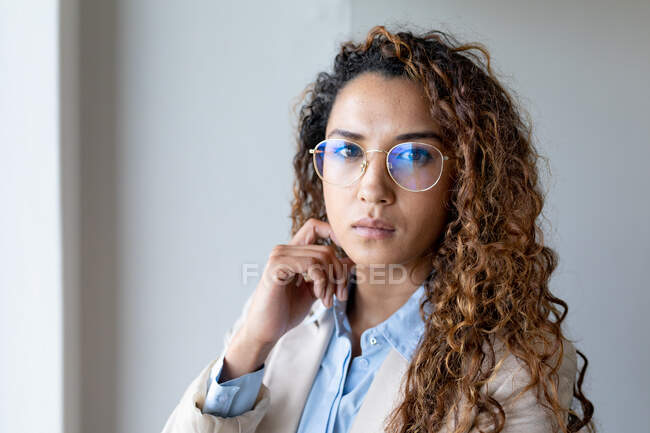 Portrait of confident biracial young businesswoman in eyeglasses at creative office. business and office workplace. — Stock Photo