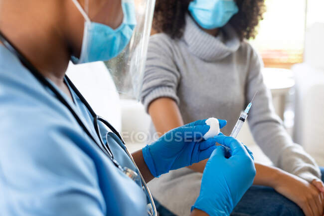 Female doctor in protective face mask holding vaccine in clinic during covid-19. healthcare services, illness prevention and pandemic. — Stock Photo