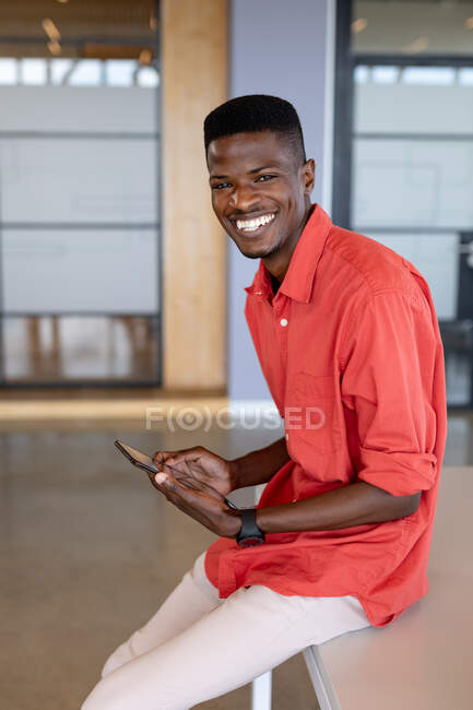 Portrait d'homme d'affaires afro-américain heureux dans les occasionnels avec tablette numérique au bureau de création. entreprise créative, bureau moderne et technologie sans fil. — Photo de stock