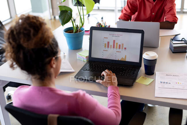 Ділова жінка в нещасних випадках аналізує графік на ноутбуці за столом у творчому офісі. креативний бізнес, сучасний офіс та бездротові технології . — стокове фото