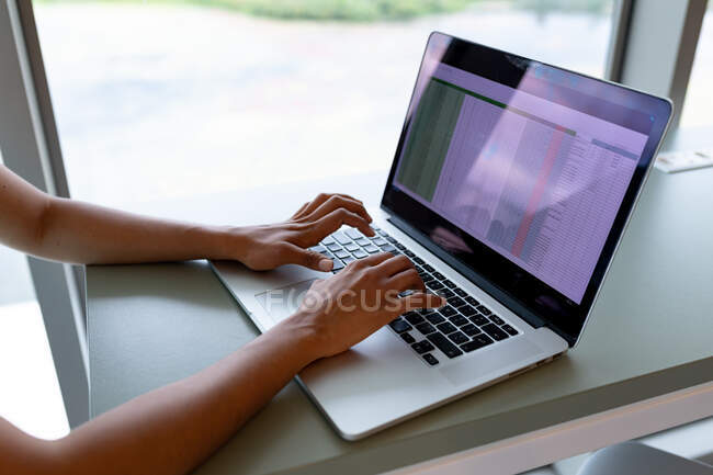Обрізані руки бізнес-леді, що працюють на ноутбуці за столом у творчому офісі. креативний бізнес, сучасний офіс та бездротові технології . — стокове фото