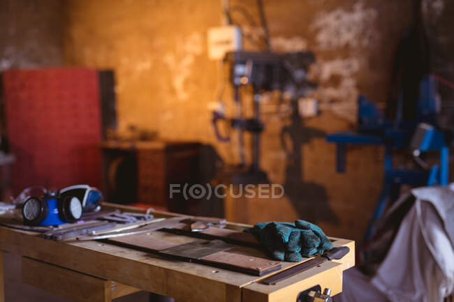 Gas mask with protective gloves and metal on workbench in manufacturing industry. forging, metalwork and manufacturing industry. — Stock Photo