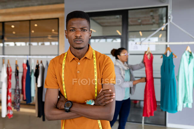 Retrato de hombre afroamericano confiado diseñador de moda en casuales de pie en la oficina creativa. negocio de diseño creativo, oficina moderna y moda. - foto de stock