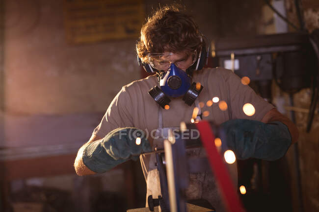 Schmied trägt Gasmaske, während er in der verarbeitenden Industrie an Metall arbeitet. Schmiede-, Metall- und Fertigungsindustrie. — Stockfoto