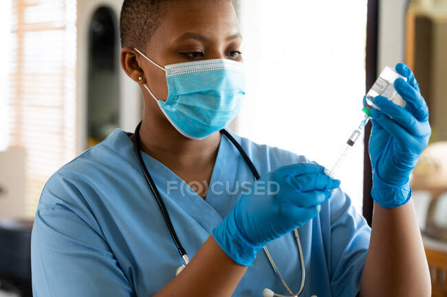 Female doctor in protective face mask filling syringe with vaccine at clinic during covid-19 crisis. healthcare services, illness prevention and pandemic. — Stock Photo