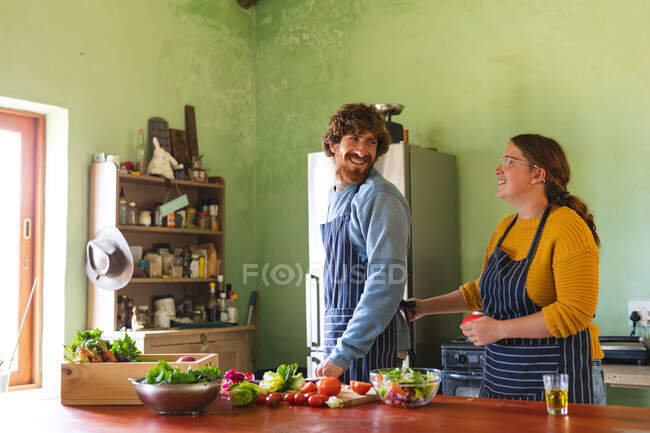 Happy young couple spending leisure time together while cooking meal in kitchen at home. domestic lifestyle and love. — Stock Photo
