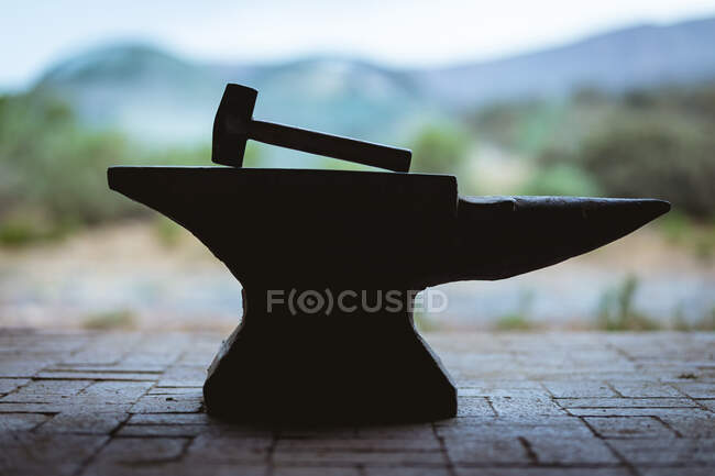 Hammer with wooden handle kept on anvil in metal industry. forging, metalwork and manufacturing industry. — Stock Photo