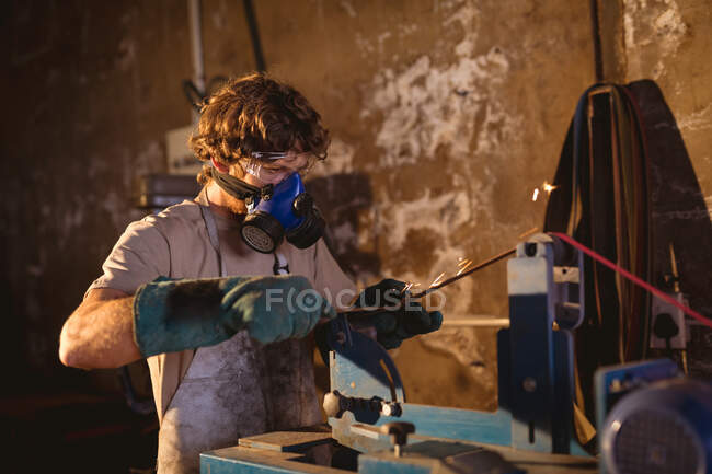 Schmied trägt Gasmaske, während er an Maschinen in der Metallindustrie arbeitet. Schmiede-, Metall- und Fertigungsindustrie. — Stockfoto