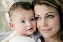 Портрет усміхненої матері і дитини обличчям до обличчя — стокове фото