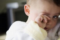 Portrait of tired baby boy rubbing eye — Stock Photo