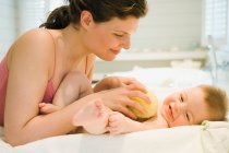 Madre lavando a su bebé - foto de stock