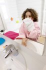 Маленька дівчинка витирає обличчя рушником у ванній — стокове фото