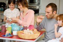 Couple and 2 little girls at breakfast table — Stock Photo