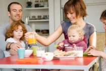 Paar und 3 Kinder am Frühstückstisch — Stockfoto