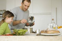 Чоловік і маленька дівчинка готують на домашній кухні — стокове фото