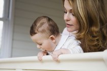 Mujer y niño mirando por la ventana - foto de stock