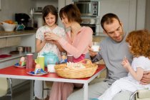 Couple and 2 little girls at breakfast table — Stock Photo
