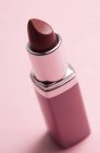Gros plan du rouge à lèvres rouge classique sur fond rose — Photo de stock