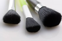 Close-up de pincéis de maquiagem na superfície branca — Fotografia de Stock