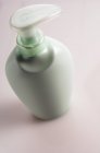 Close-up of mint colored soap dispenser on pink background — Stock Photo