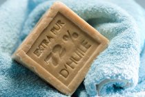 Primo piano di sapone naturale su asciugamano azzurro — Foto stock