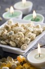 Primo piano di fiori di camomilla essiccati su piatto e candele in spa — Foto stock