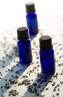 Nahaufnahme von blauen ätherischen Ölflaschen und getrockneten Körnern — Stockfoto