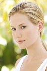 Portrait of young blond woman looking at camera outdoors — Stock Photo