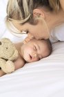 Retrato de mãe beijando dormindo bebê menino — Fotografia de Stock