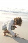 Petit garçon jouer avec le sable sur la plage — Photo de stock