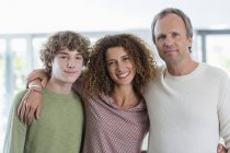Retrato de familia feliz sonriendo en casa - foto de stock