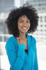 Portrait de femme souriante avec coiffure afro en haut à capuchon bleu — Photo de stock