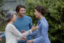 Happy mature woman meeting young couple outdoors — Stock Photo