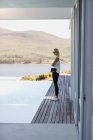 Profilo di giovane donna in piedi sul lungomare sulla riva del lago e guardando la vista — Foto stock