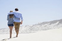Vista posteriore di coppia romantica passeggiando sulla spiaggia di sabbia — Foto stock