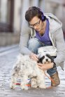 Мужчина открывает поводок для собаки на городской улице — стоковое фото