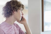 Хлопчик-підліток розмовляє на мобільному телефоні вдома — стокове фото