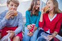 Friends enjoying fast food together — Stock Photo