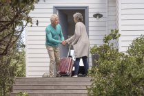 Älterer Mann begrüßt Frau an Haustür — Stockfoto