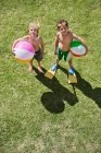 Портрет мальчиков, держащих пляжные мячи — стоковое фото