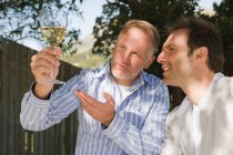 Dois amigos olhando para um copo de vinho — Fotografia de Stock