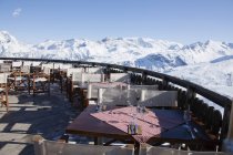 Restaurante terraza rodeada de montañas cubiertas de nieve - foto de stock