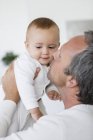 Glücklicher Vater küsst süße kleine Tochter zu Hause — Stockfoto