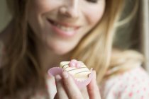 Крупним планом усміхнена жінка їсть кекс — стокове фото