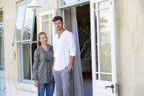 Young couple standing together in front of house — Stock Photo