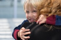 Щасливий маленький хлопчик обіймає матір — стокове фото